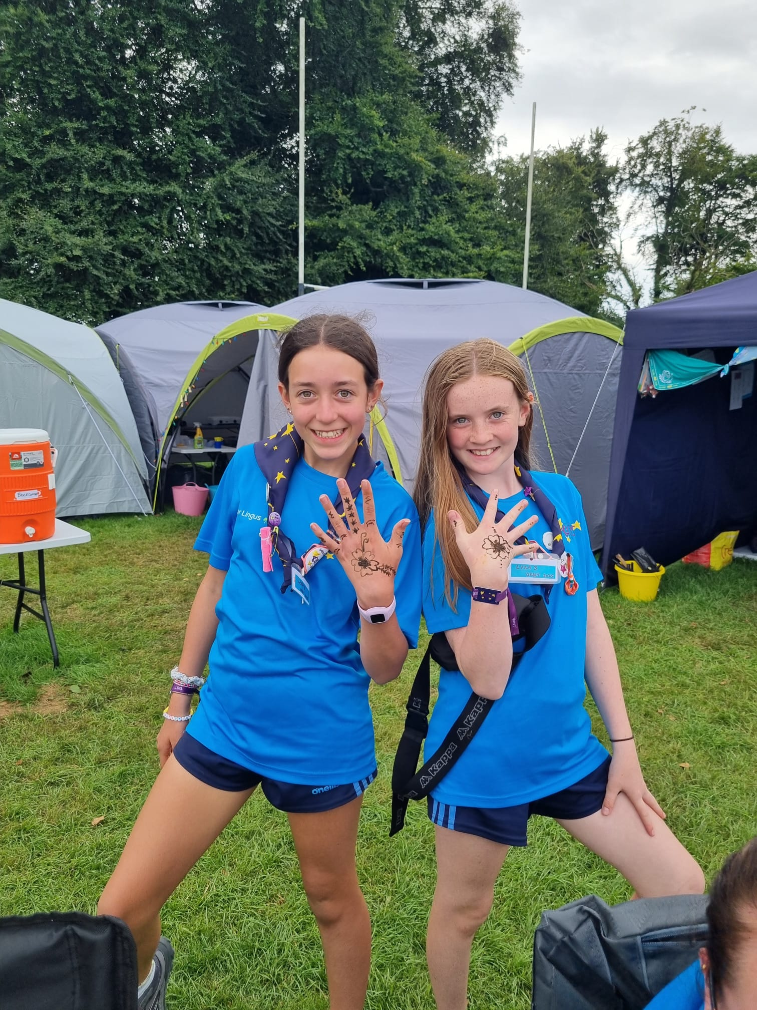 Two Guides on campsite at Orbit 2025 - showing their hands with henna